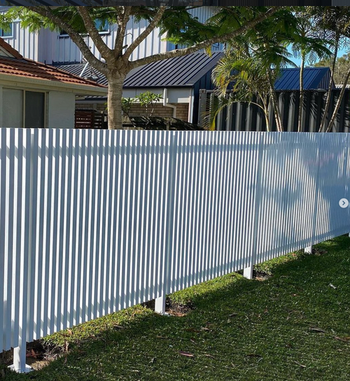 White slatted aluminum fence with a residential background