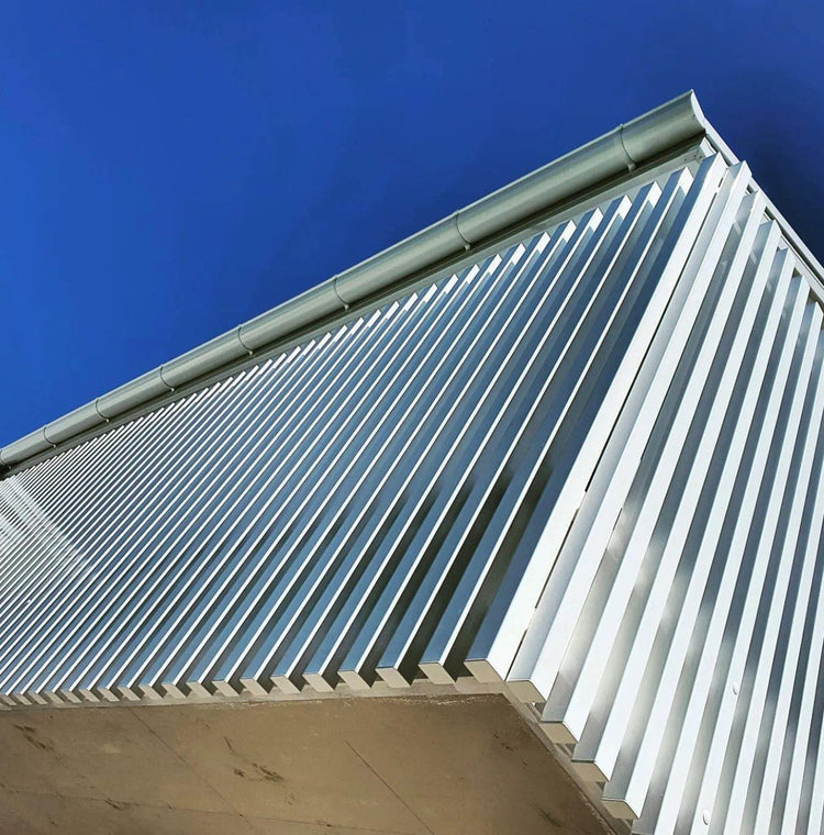 Close-up of aluminum facade fins with square aluminum end caps installed on each section.