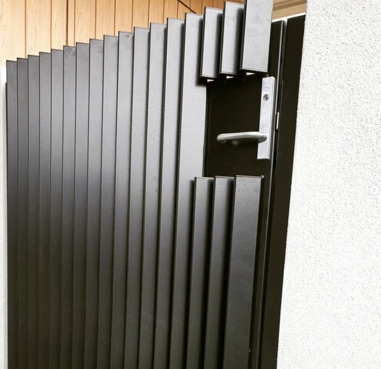 Black aluminum pedestrian gate with square end caps fitted into vertical battens.