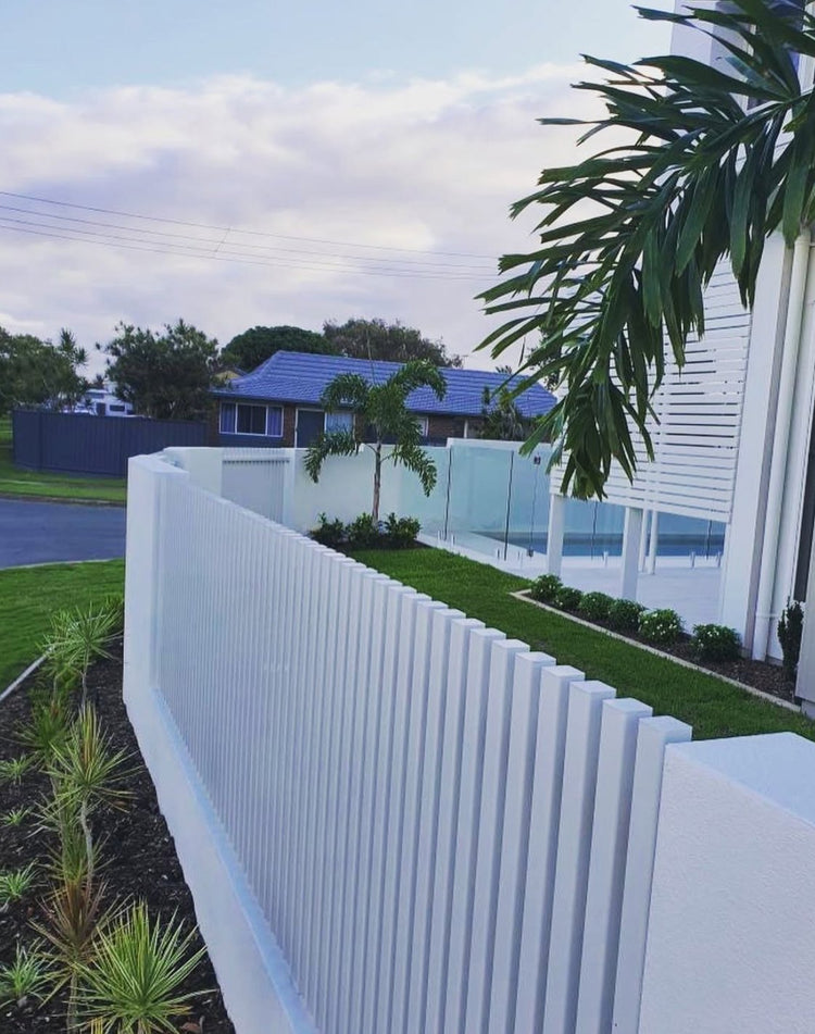 White aluminum privacy fence with vertical battens finished using interference-fit aluminum end caps.