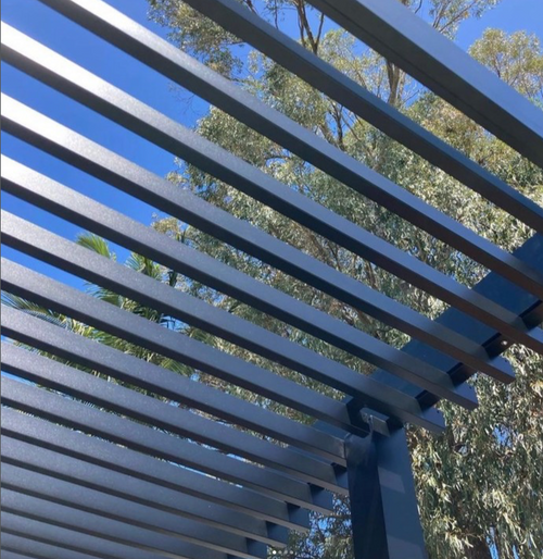 Blue metal pergola with trees in the background